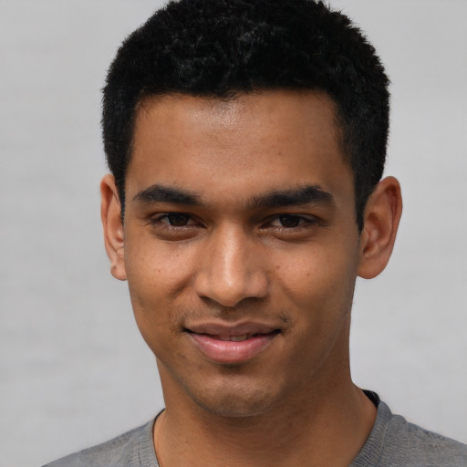 Joyful black young-adult male with short  black hair and brown eyes