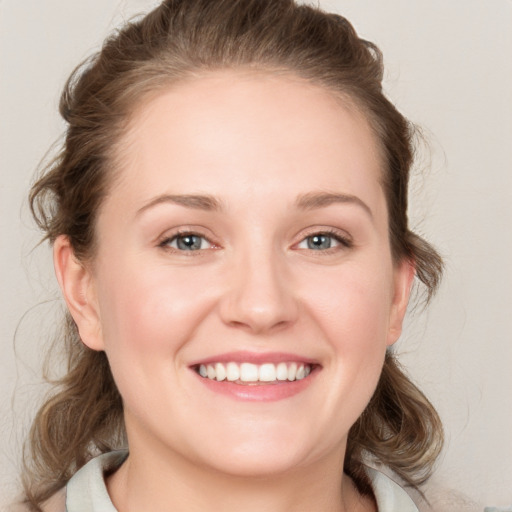 Joyful white young-adult female with medium  brown hair and blue eyes