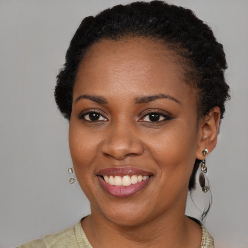 Joyful black young-adult female with short  brown hair and brown eyes