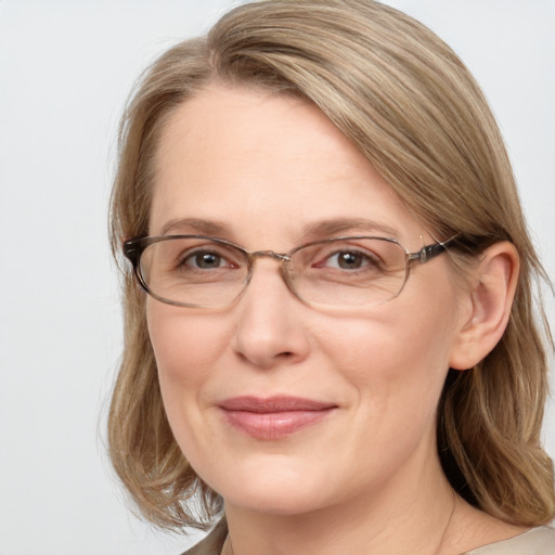 Joyful white adult female with medium  brown hair and blue eyes