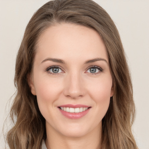 Joyful white young-adult female with long  brown hair and green eyes