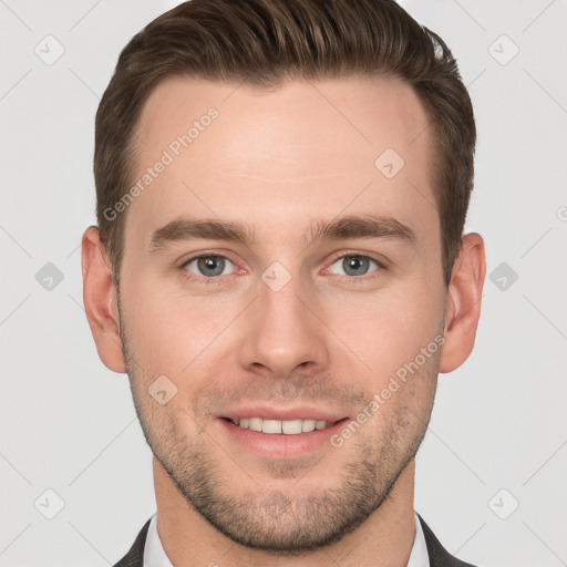 Joyful white young-adult male with short  brown hair and grey eyes