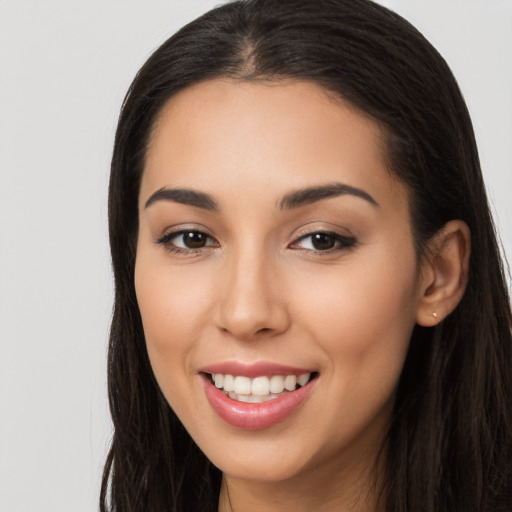 Joyful latino young-adult female with long  brown hair and brown eyes