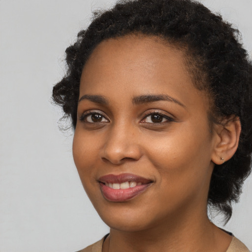 Joyful black young-adult female with long  black hair and brown eyes