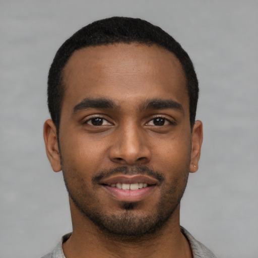 Joyful black young-adult male with short  black hair and brown eyes