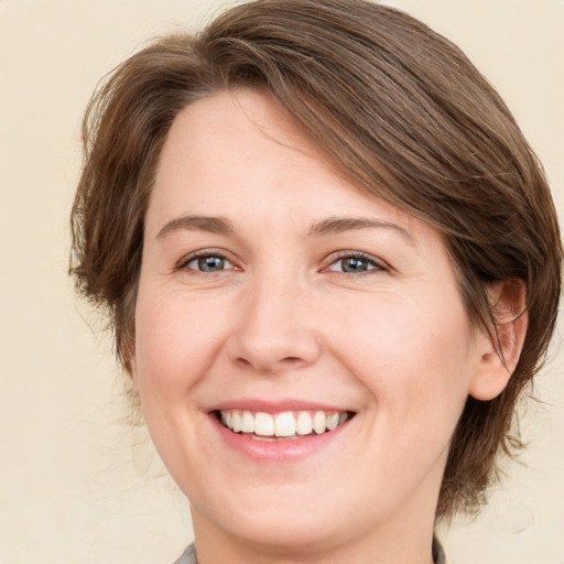 Joyful white young-adult female with medium  brown hair and green eyes