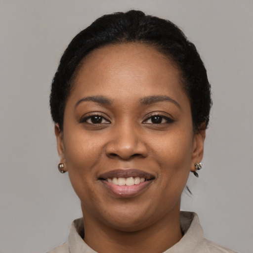 Joyful black young-adult female with short  black hair and brown eyes