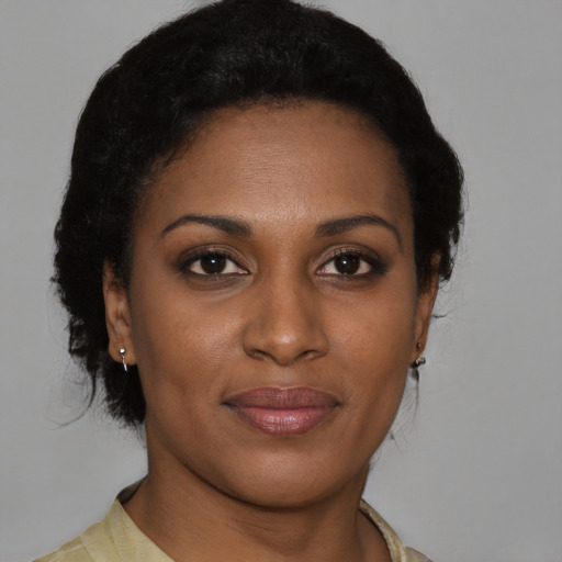 Joyful black young-adult female with short  brown hair and brown eyes