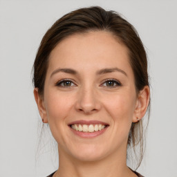 Joyful white young-adult female with medium  brown hair and grey eyes