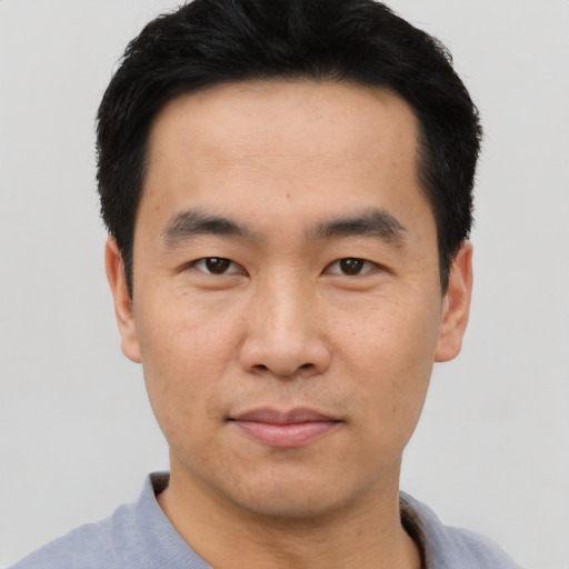 Joyful asian young-adult male with short  black hair and brown eyes