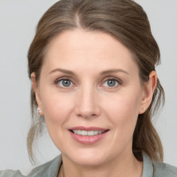 Joyful white young-adult female with medium  brown hair and grey eyes