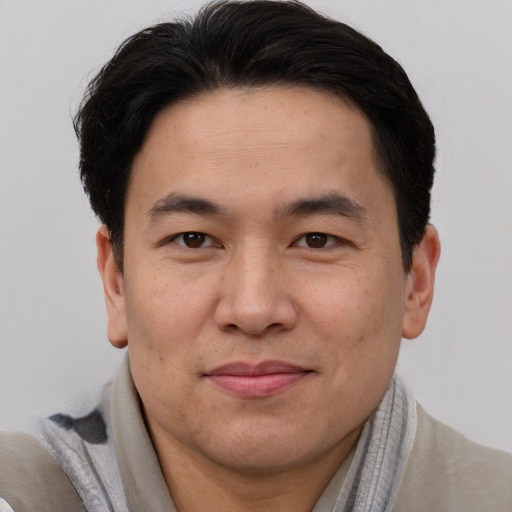 Joyful asian adult male with short  brown hair and brown eyes