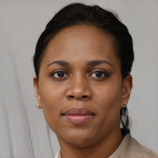 Joyful black young-adult female with short  black hair and brown eyes
