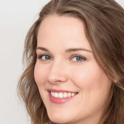 Joyful white young-adult female with long  brown hair and green eyes