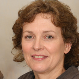 Joyful white adult female with medium  brown hair and blue eyes