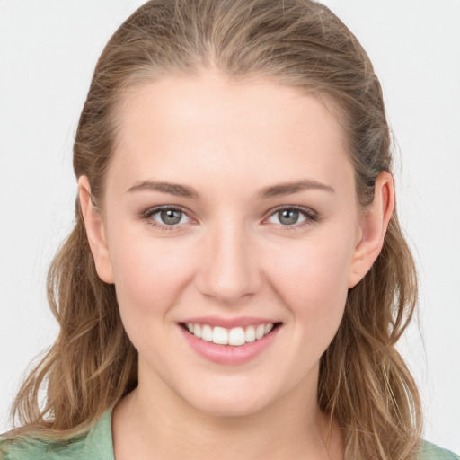 Joyful white young-adult female with long  brown hair and grey eyes