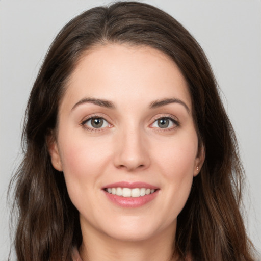 Joyful white young-adult female with long  brown hair and brown eyes