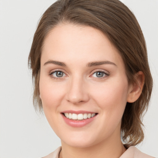 Joyful white young-adult female with medium  brown hair and green eyes