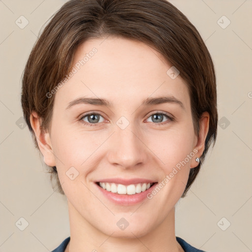 Joyful white young-adult female with medium  brown hair and grey eyes