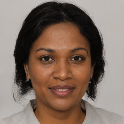 Joyful black young-adult female with medium  brown hair and brown eyes