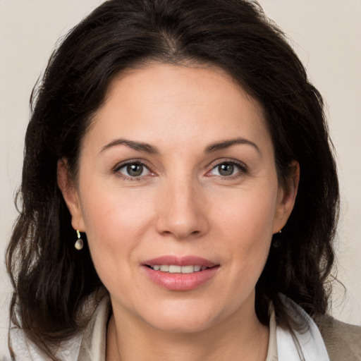 Joyful white adult female with medium  brown hair and brown eyes