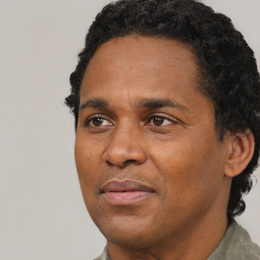 Joyful black adult male with short  black hair and brown eyes