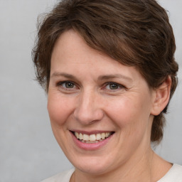 Joyful white adult female with medium  brown hair and grey eyes