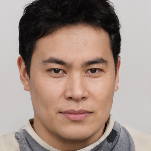 Joyful asian young-adult male with short  brown hair and brown eyes