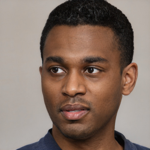 Joyful black young-adult male with short  black hair and brown eyes