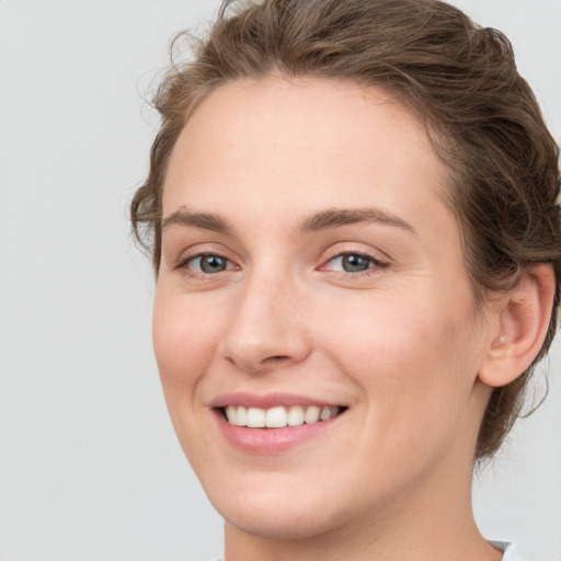 Joyful white young-adult female with medium  brown hair and green eyes