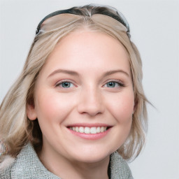 Joyful white young-adult female with medium  brown hair and blue eyes