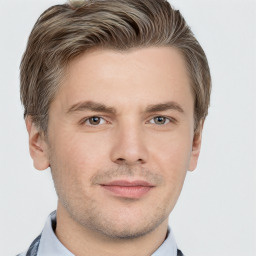 Joyful white young-adult male with short  brown hair and grey eyes