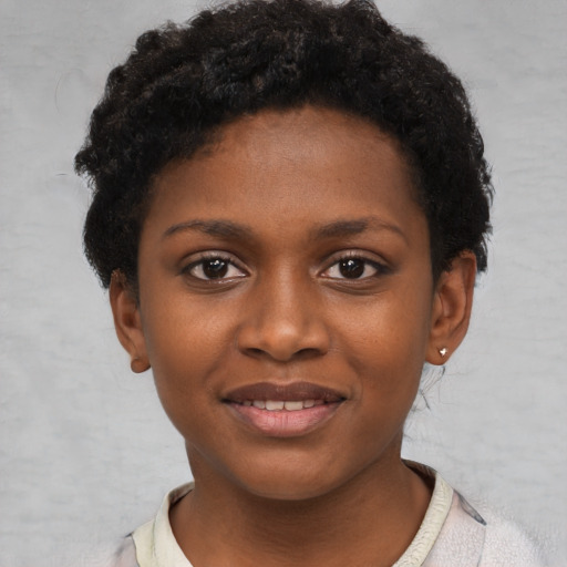 Joyful black child female with short  black hair and brown eyes