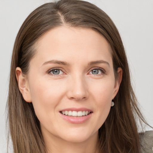 Joyful white young-adult female with long  brown hair and grey eyes