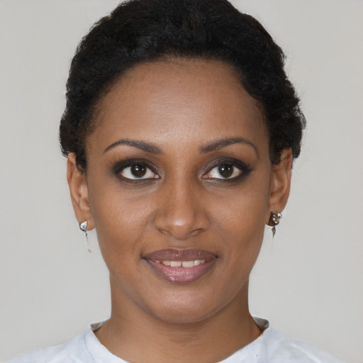 Joyful black young-adult female with short  brown hair and brown eyes
