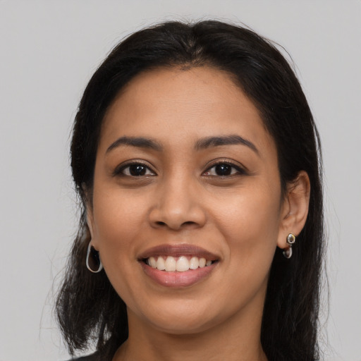 Joyful latino young-adult female with long  brown hair and brown eyes