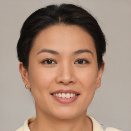 Joyful asian young-adult female with short  brown hair and brown eyes