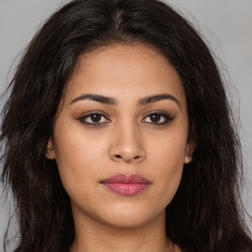 Joyful latino young-adult female with long  brown hair and brown eyes