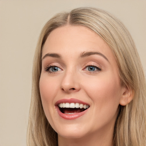 Joyful white young-adult female with long  brown hair and blue eyes