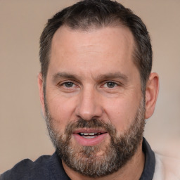 Joyful white adult male with short  brown hair and brown eyes