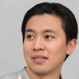 Joyful asian young-adult male with short  brown hair and brown eyes