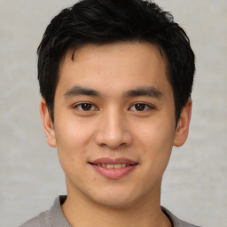 Joyful asian young-adult male with short  black hair and brown eyes