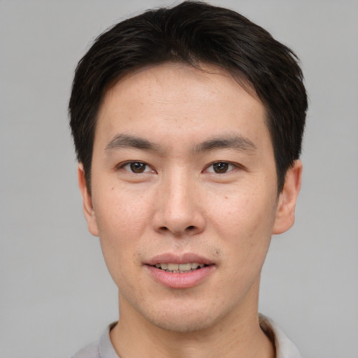 Joyful asian young-adult male with short  brown hair and brown eyes