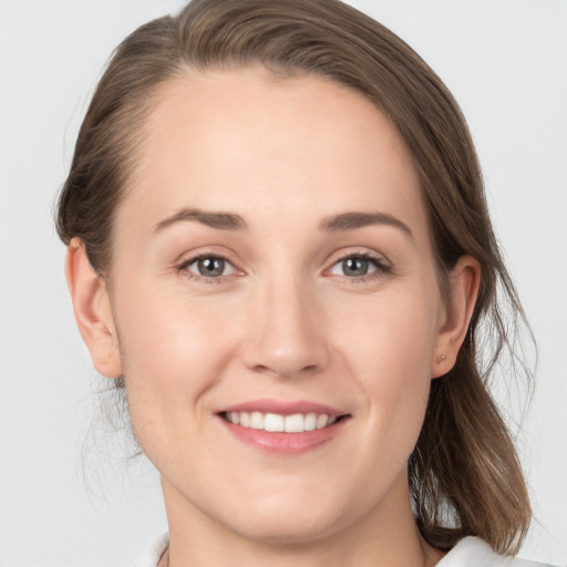 Joyful white young-adult female with medium  brown hair and grey eyes