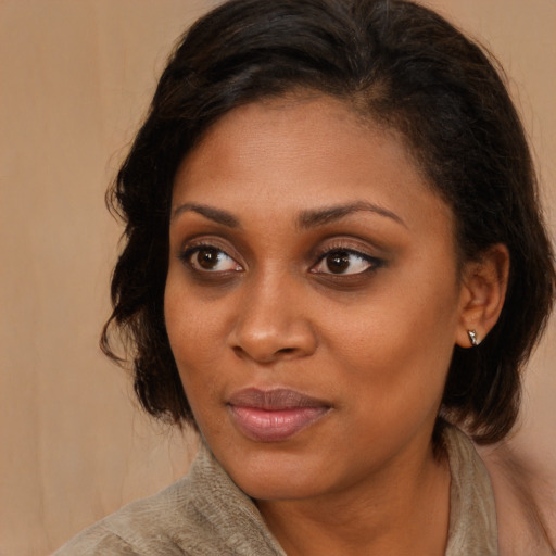 Joyful black young-adult female with medium  brown hair and brown eyes