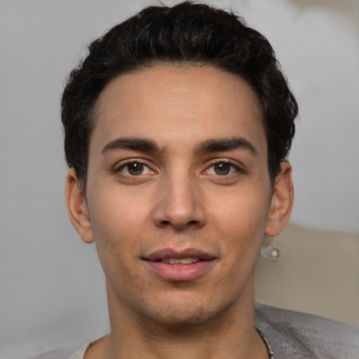 Joyful white young-adult male with short  black hair and brown eyes