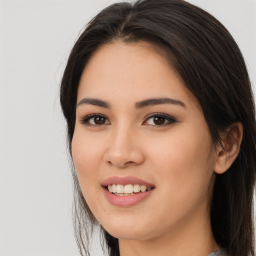Joyful asian young-adult female with long  brown hair and brown eyes