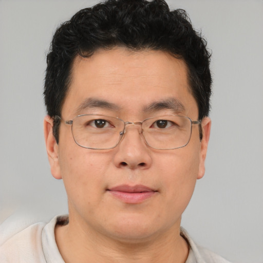 Joyful asian adult male with short  brown hair and brown eyes