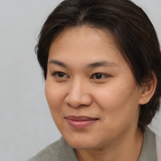 Joyful asian young-adult female with medium  brown hair and brown eyes