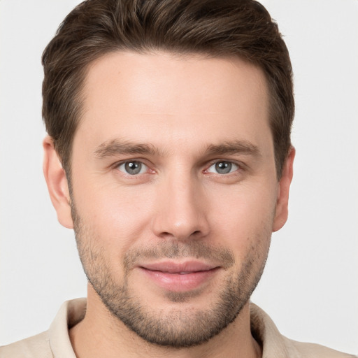 Joyful white young-adult male with short  brown hair and grey eyes